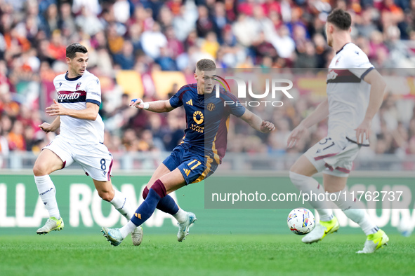 Remo Freuler of Bologna FC and Artem Dovbyk of AS Roma compete for the ball during the Serie A Enilive match between AS Roma and Bologna FC...