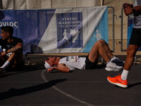 A marathon runner lies on the ground immediately after finishing the Athens Marathon in Athens, Greece, on November 10, 2024 (