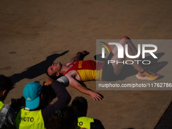 A marathon runner lies on the ground immediately after finishing the Athens Marathon in Athens, Greece, on November 10, 2024 (