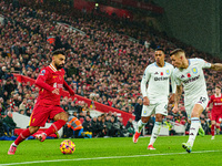 Liverpool's Mohamed Salah competes with Aston Villa's Jacob Ramsey and Lucas Digne during the Premier League match between Liverpool and Ast...