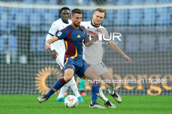 Bryan Cristante of AS Roma and Tommaso Pobega of Bologna FC compete for the ball during the Serie A Enilive match between AS Roma and Bologn...