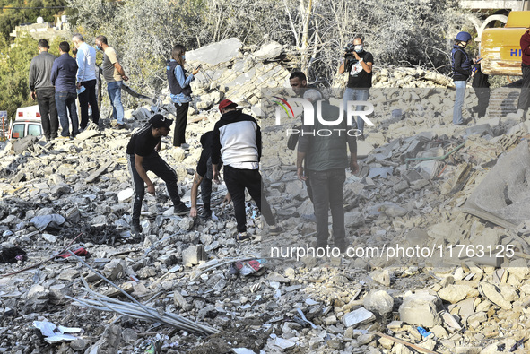 Rescuers search for survivors at the site of an Israeli airstrike that targets the village of Almat north of Beirut, Lebanon, on November 10...