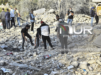 Rescuers search for survivors at the site of an Israeli airstrike that targets the village of Almat north of Beirut, Lebanon, on November 10...