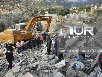 Rescuers search for survivors at the site of an Israeli airstrike that targets the village of Almat north of Beirut, Lebanon, on November 10...