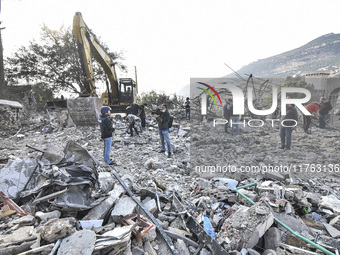 Rescuers search for survivors at the site of an Israeli airstrike that targets the village of Almat north of Beirut, Lebanon, on November 10...