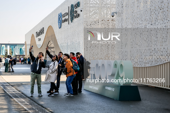 Participants walk by an entrance of COP29, UN Climate Change Conference venue, an event held by UNFCCC in Baku Olympic Stadium in Baku, the...