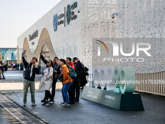 Participants walk by an entrance of COP29, UN Climate Change Conference venue, an event held by UNFCCC in Baku Olympic Stadium in Baku, the...