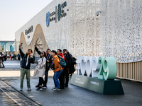 Participants walk by an entrance of COP29, UN Climate Change Conference venue, an event held by UNFCCC in Baku Olympic Stadium in Baku, the...