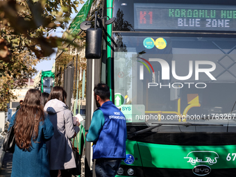 Participants walk by an entrance of COP29, UN Climate Change Conference venue, an event held by UNFCCC in Baku Olympic Stadium in Baku, the...