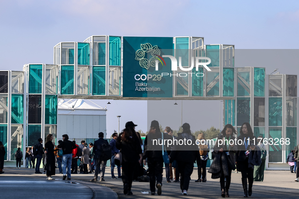 Participants walk by an entrance of COP29, UN Climate Change Conference venue, an event held by UNFCCC in Baku Olympic Stadium in Baku, the...