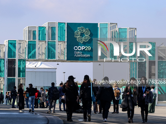 Participants walk by an entrance of COP29, UN Climate Change Conference venue, an event held by UNFCCC in Baku Olympic Stadium in Baku, the...