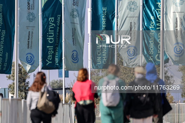 Participants walk by an entrance of COP29, UN Climate Change Conference venue, an event held by UNFCCC in Baku Olympic Stadium in Baku, the...