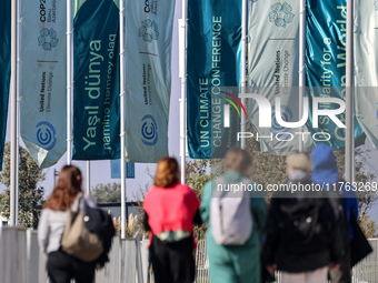 Participants walk by an entrance of COP29, UN Climate Change Conference venue, an event held by UNFCCC in Baku Olympic Stadium in Baku, the...