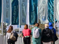 Participants walk by an entrance of COP29, UN Climate Change Conference venue, an event held by UNFCCC in Baku Olympic Stadium in Baku, the...