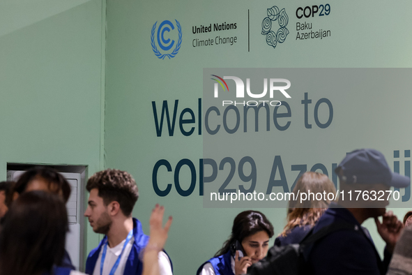 Participants walk by an entrance of COP29, UN Climate Change Conference venue, an event held by UNFCCC in Baku Olympic Stadium in Baku, the...