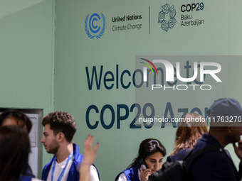 Participants walk by an entrance of COP29, UN Climate Change Conference venue, an event held by UNFCCC in Baku Olympic Stadium in Baku, the...