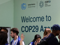 Participants walk by an entrance of COP29, UN Climate Change Conference venue, an event held by UNFCCC in Baku Olympic Stadium in Baku, the...