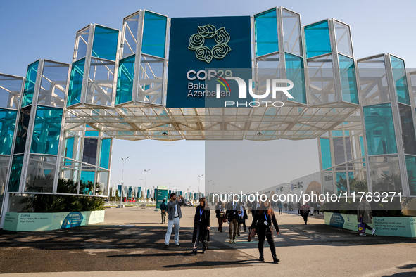 Participants walk by an entrance of COP29, UN Climate Change Conference venue, an event held by UNFCCC in Baku Olympic Stadium in Baku, the...