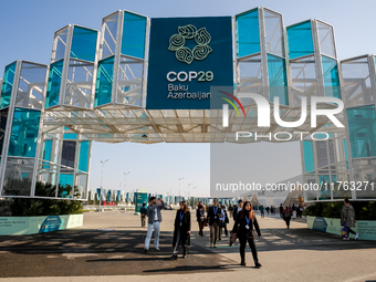 Participants walk by an entrance of COP29, UN Climate Change Conference venue, an event held by UNFCCC in Baku Olympic Stadium in Baku, the...