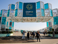 Participants walk by an entrance of COP29, UN Climate Change Conference venue, an event held by UNFCCC in Baku Olympic Stadium in Baku, the...