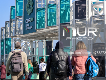 Participants walk by an entrance of COP29, UN Climate Change Conference venue, an event held by UNFCCC in Baku Olympic Stadium in Baku, the...