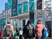 Participants walk by an entrance of COP29, UN Climate Change Conference venue, an event held by UNFCCC in Baku Olympic Stadium in Baku, the...