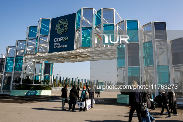 Participants walk by an entrance of COP29, UN Climate Change Conference venue, an event held by UNFCCC in Baku Olympic Stadium in Baku, the...