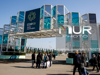 Participants walk by an entrance of COP29, UN Climate Change Conference venue, an event held by UNFCCC in Baku Olympic Stadium in Baku, the...