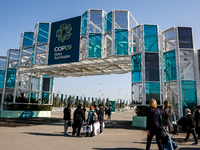 Participants walk by an entrance of COP29, UN Climate Change Conference venue, an event held by UNFCCC in Baku Olympic Stadium in Baku, the...