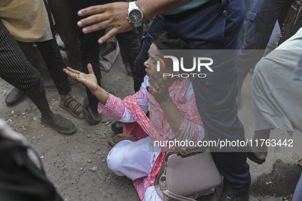 A police officer shields an Awami League woman supporter from students from anti-discrimination movements and Bangladesh Nationalist Party a...