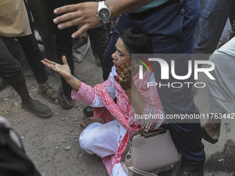 A police officer shields an Awami League woman supporter from students from anti-discrimination movements and Bangladesh Nationalist Party a...