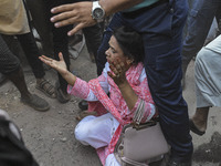 A police officer shields an Awami League woman supporter from students from anti-discrimination movements and Bangladesh Nationalist Party a...