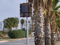 A solar-powered speed indicator installed along a palm-lined road aims to promote safe driving by monitoring and displaying vehicle speeds....