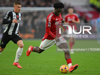 Ola Aina of Nottingham Forest is under pressure from Harvey Barnes of Newcastle United during the Premier League match between Nottingham Fo...