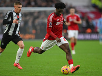 Ola Aina of Nottingham Forest is under pressure from Harvey Barnes of Newcastle United during the Premier League match between Nottingham Fo...