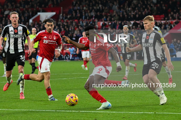 Taiwo Awoniyi of Nottingham Forest is under pressure from Lewis Hall of Newcastle United during the Premier League match between Nottingham...