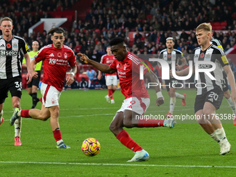 Taiwo Awoniyi of Nottingham Forest is under pressure from Lewis Hall of Newcastle United during the Premier League match between Nottingham...