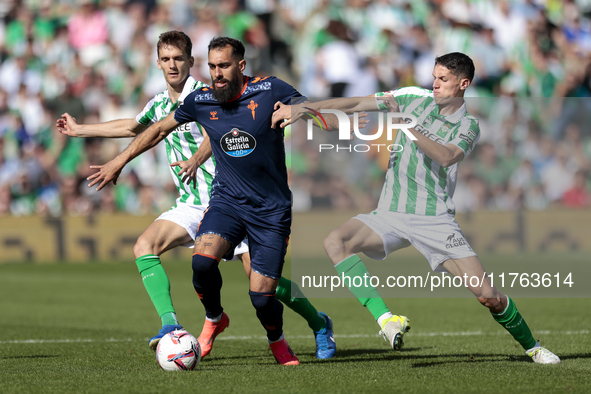 In Seville, Spain, on November 10, 2024, Borja Iglesias of RC Celta de Vigo competes for the ball with Diego Llorente and Sergi Altimira of...