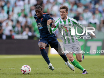 Iker Losada of Real Betis competes for the ball with Ilaix Moriba of RC Celta de Vigo during the La Liga EA Sport match between Real Betis a...