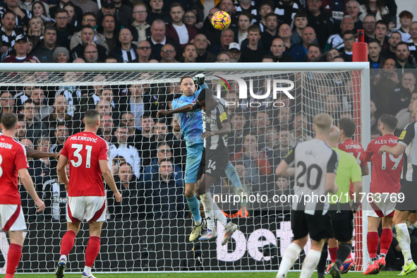 Matz Sels, the Nottingham Forest goalkeeper, punches the ball clear under pressure from Alexander Isak of Newcastle United during the Premie...