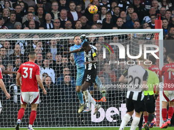 Matz Sels, the Nottingham Forest goalkeeper, punches the ball clear under pressure from Alexander Isak of Newcastle United during the Premie...