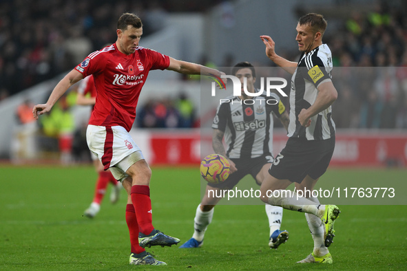 Chris Wood of Nottingham Forest and Dan Burn of Newcastle United participate in the Premier League match between Nottingham Forest and Newca...