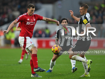 Chris Wood of Nottingham Forest and Dan Burn of Newcastle United participate in the Premier League match between Nottingham Forest and Newca...