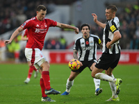 Chris Wood of Nottingham Forest and Dan Burn of Newcastle United participate in the Premier League match between Nottingham Forest and Newca...