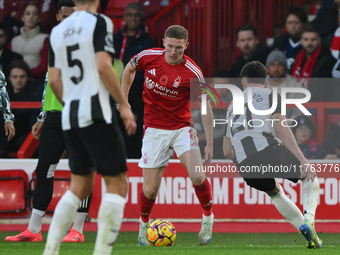 Elliott Anderson of Nottingham Forest is under pressure from Tino Livramento of Newcastle United during the Premier League match between Not...