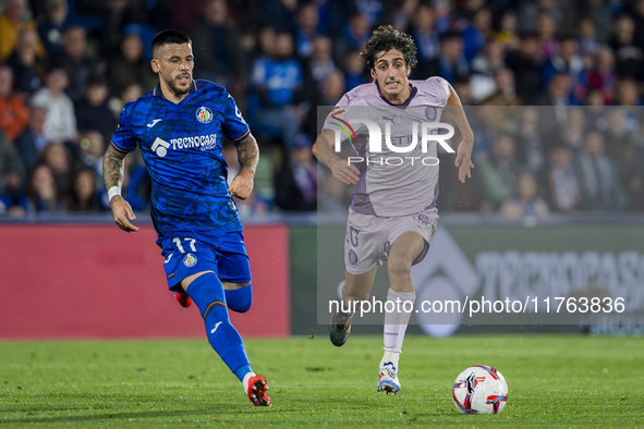 Bryan Gil of Girona FC (R) is in action against Carles Perez of Getafe CF (L) during the La Liga EA Sports 2024/25 football match between Ge...