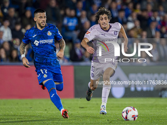 Bryan Gil of Girona FC (R) is in action against Carles Perez of Getafe CF (L) during the La Liga EA Sports 2024/25 football match between Ge...