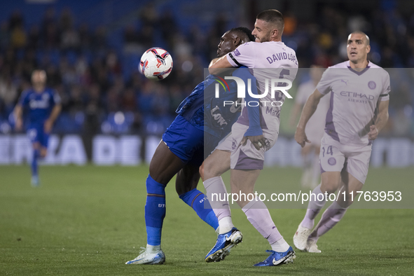 In Madrid, Spain, on November 10, Christantus Uche of Getafe and David Lopez of Girona fight for the ball during the La Liga 2024/25 match b...