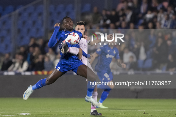 In Madrid, Spain, on November 10, Domingos Duarte of Getafe and Arnau Martinez of Girona fight for the ball during the La Liga 2024/25 match...