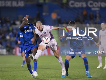 Oriol Romeu of Girona, Allan Romeo Nyom of Getafe, and Yellu Santiago of Getafe fight for the ball during the La Liga 2024/25 match between...